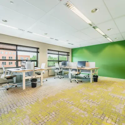 Moderne kantoorruimte te huur op Rijnzathe 12 in De Meern, compleet met bureaus en ergonomische stoelen in een lichte omgeving met groene accenten.