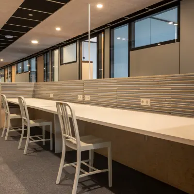 Moderne kantoorruimte huren op Delftechpark 9 in Delft, met lange werktafels en comfortabele stoelen, ideaal voor efficiënt kantoorwerk.