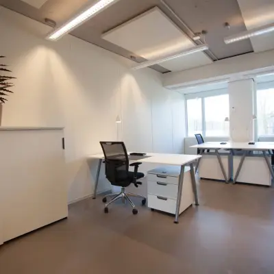 Moderne kantoorruimte te huur op Poortweg 4, Delft met strakke inrichting, grote ramen en enkele werkplekken.