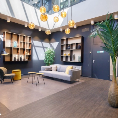 Moderne kantoorruimte huren in Den Bosch met stijlvolle inrichting, lichte zithoek en decoratieve elementen. Ideaal voor informele ontmoetingen in kantoorpand aan de Europalaan 2.