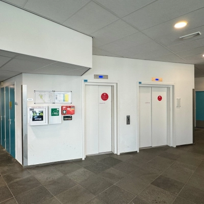 Ingang van het kantoorpand op Platinaweg 10 in Den Haag Escamp, met liften en heldere muren. Perfecte locatie voor kantoorruimte huren.