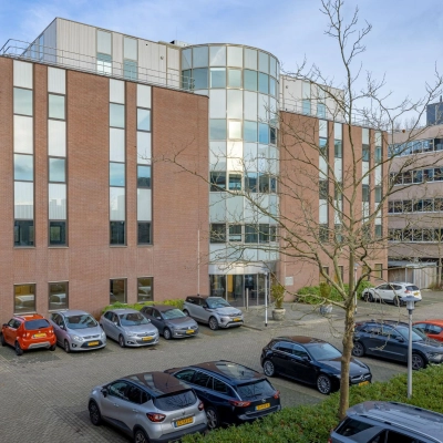 Exterieur van het kantoorpand Wisselwerking 40-48 te Diemen, met meerdere geparkeerde auto's op de voorgrond. Kantoorruimte huren in een modern, veelzijdig gebouw.