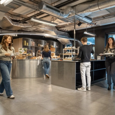 Kantoorruimte op Flight Forum 120-159 in Eindhoven met moderne pantry en mensen bezig met koffie en snacks.