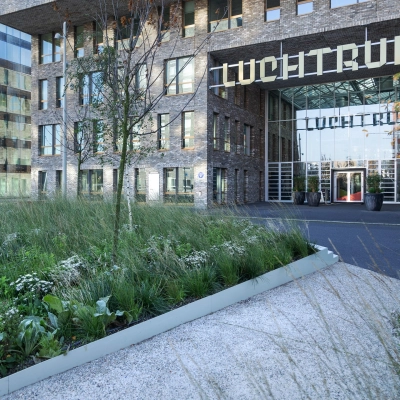 Buitenzicht op het moderne kantoorpand Flight Forum 120-159 in Eindhoven Airport, omringd door groen. Deze locatie biedt diverse mogelijkheden voor kantoorruimte huren.