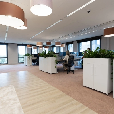 Moderne kantoorruimte op Flight Forum 120-159, Eindhoven Airport met bureaus, kantoormeubilair en planten. Zakelijke professionals werken aan computers binnen deze lichte, productieve omgeving. Kantoorruimte huren in een inspirerende atmosfeer.