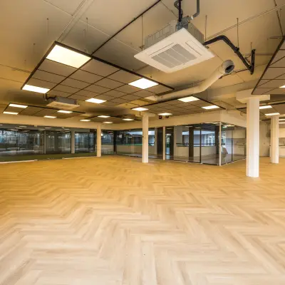 Ruime lege kantoorruimte op Luchthavenweg 81, Eindhoven Airport, met houten vloer en groot raam voor veel lichtinval. Ideaal voor wie een modern en aanpasbaar kantoorpand wil huren.