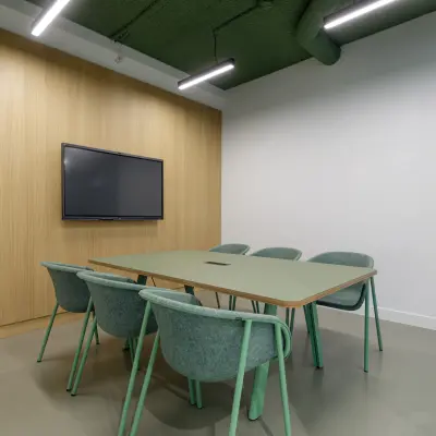 Moderne conferentieruimte met groene tafel en stoelen op Paradijslaan 30-38 in Eindhoven Centrum, perfect voor kantoorgebruik of vergaderingen.
