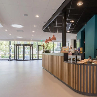 Moderne entree van het kantoorpand aan Professor Dr Dorgelolaan 14 in Eindhoven Centrum met een stijlvolle balie en glazen deuren. Het interieur oogt professioneel voor wie kantoorruimte huren overweegt.