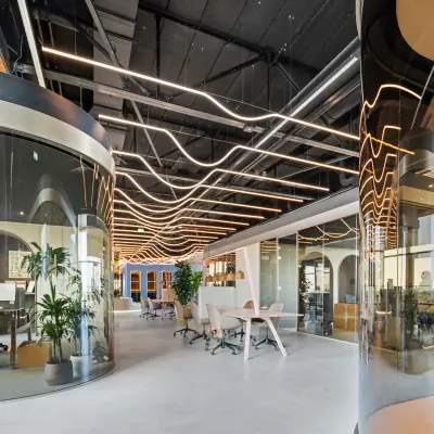 Moderne kantoorruimte met glazen wanden en unieke verlichting in kantoorpand op Achtseweg Zuid 159R, Eindhoven Strijp-S, ideaal voor het huren van inspirerende werkplekken.