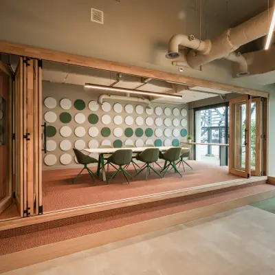 Moderne kantoorpand op Frederiklaan 10E, Eindhoven Strijp-S, met vergadertafel en zitgelegenheid in een heldere ruimte. Ideaal voor kantoorruimte huren met veel natuurlijk licht en een stijlvol interieur.