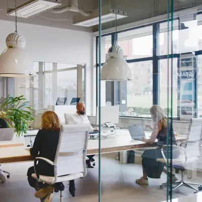 Kantoorruimte huren in Eindhoven Strijp-S op Torenallee 20 met moderne werkplekken en personen die aan bureaus werken in een lichte omgeving.