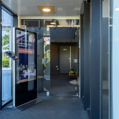 Ingang van kantoorpand op Marssteden 20 in Enschede met moderne glazen deuren en informatiezuil. Ideale plek voor kantoorruimte huren.