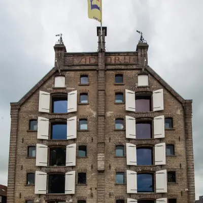 Authentiek kantoorpand aan de Prins Hendrikkade 3, Franeker, met karakteristieke bakstenen gevel en opvallende luiken. Perfecte optie voor kantoorruimte huren in een charmante omgeving.