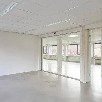 Lichte, open kantoorruimte te huur op de Schweitzerlaan 12 in Groningen met glazen wanden en veel natuurlijk licht.