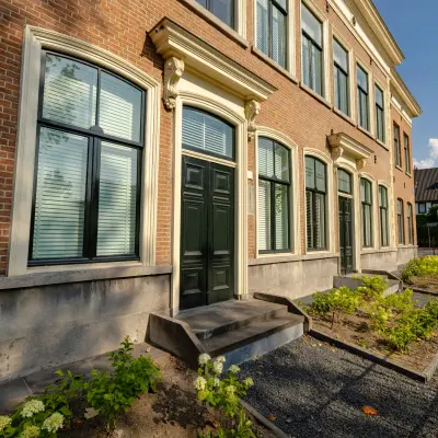 Buitenkant van een kantoorpand op Kennemerplein 20, Haarlem Centraal Station. Traditioneel met baksteen, grote ramen en een klassieke uitstraling. Kantoorruimte huren in deze locatie biedt charme en toegankelijkheid.