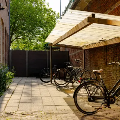 Buitenruimte bij kantoorpand op Kennemerplein 20, Haarlem Centraal Station, met fietsen onder een afdak.
