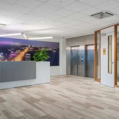 Moderne receptie in een kantoorpand op A. Hofmanweg 5A, Haarlem Waarderpolder, met een balie, plant en kunstwerk. Kantoorruimte huren zonder gedoe.