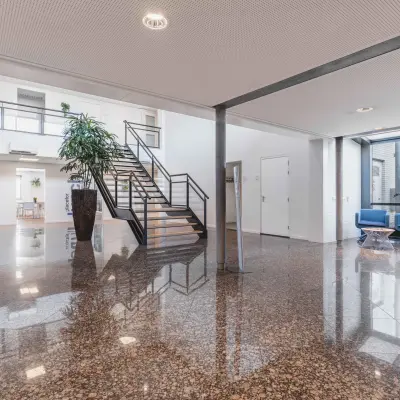 Ruime entree in het kantoorpand aan de Steenovenweg 5 in Helmond, met glazen gevels en een moderne trap. Ideaal voor wie kantoorruimte wil huren in een professionele omgeving.