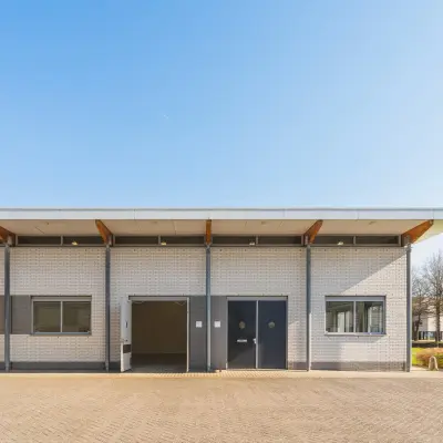 Exterieur van een kantoorpand op Steenovenweg 5 in Helmond, geschikt voor kantoorruimte huren. Bakstenen gevel met moderne ramen en een inrit.