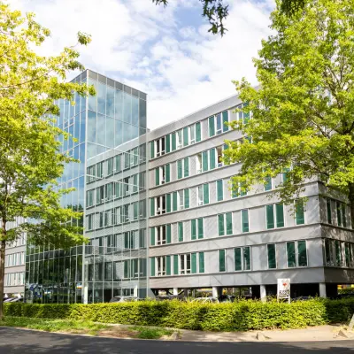 Modern kantoorpand aan de Demmersweg 3 in Hengelo, omringd door bomen. Kantoorruimte huren in een strak ontwerp met veel glas en meerdere verdiepingen.