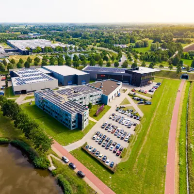 Luchtfoto van het kantoorpand aan de Jan Tinbergenstraat 202 in Hengelo, omringd door groen en parkeerplaatsen. Ideale locatie voor kantoorruimte huren.