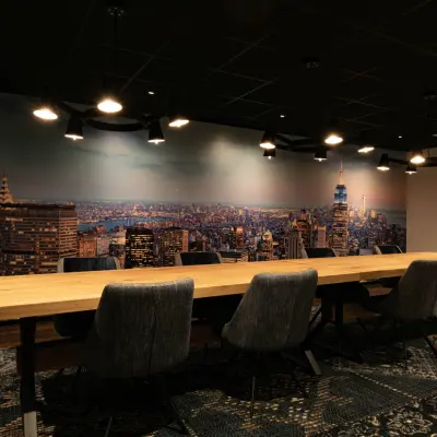 Vergaderruimte in kantoorpand op Steijnlaan 16, Hilversum met lange houten tafel en stoelen, gedecoreerd met een stadsfoto op de muur.
