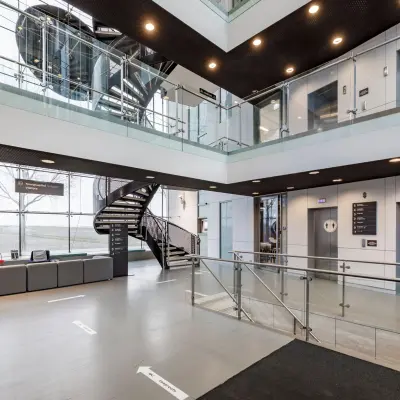 Moderne entree van een kantoorpand op Siriusdreef 16 in Hoofddorp met loungeset en liften. Perfect voor bedrijven die kantoorruimte willen huren.