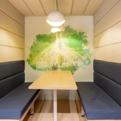 Moderne vergaderruimte met houten tafel en blauwe zitbanken in kantoor aan Siriusdreef 17, Hoofddorp. Geschikt voor ondernemers die kantoorruimte willen huren.