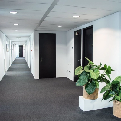 Lichte gang in kantoorpand Meidoornkade 22 in Houten met planten langs de muur, ideaal voor kantoorruimte huren.