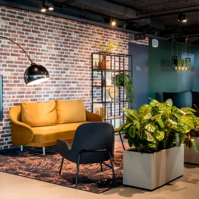 Stijlvolle kantoorruimte huren op Bargelaan 200, Leiden met een moderne zithoek, planten en wanddecoratie. Ideaal voor huurders die op zoek zijn naar een creatieve werkplek in een kantoorpand.