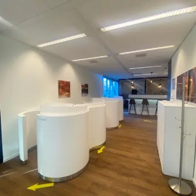 Moderne kantoorruimte met houten vloer en witte meubels, geschikt voor zakelijke activiteiten in kantoorpand op Mendelweg 30, Leiden. Ideaal voor wie een kantoorruimte wil huren.