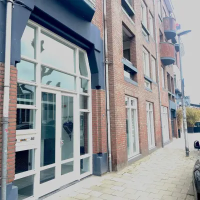 Buitenzijde van het kantoorpand op Wilhelminasingel 44-46 in Maastricht, met grote ramen en een rood bakstenen gevel. Ideaal voor kantoorruimte huren.