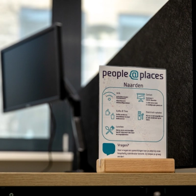 Moderne kantoorruimte huren in Naarden aan het Gooimeer 1, met een strakke werkplek en monitoren op houten bureaus. Inspirerende omgeving voor professionele activiteiten.