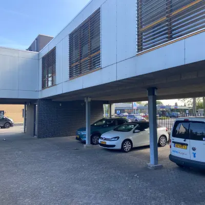 Buitenkant van een kantoorpand op Abdis van Thornstraat 74 in Oosterhout Nb, met parkeerplaatsen eronder. Ideaal voor wie kantoorruimte wil huren.