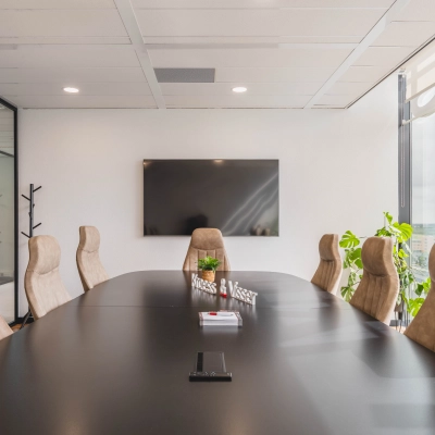 Moderne vergaderruimte in kantoorpand aan Laan van Zuid Hoorn 70, Rijswijk, met grote tafel, comfortabele stoelen, tv en veel lichtinval. Ideaal voor kantoorruimte huren.
