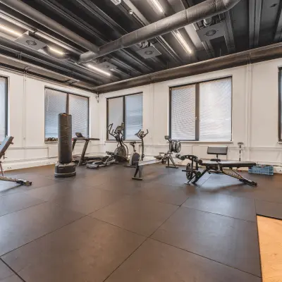 Een kantoorpand aan de Lange Kleiweg 50-62 in Rijswijk met een fitnessruimte, compleet met verschillende fitnessapparaten en enkele banken, biedt mogelijkheden voor kantoorruimte huren met goede voorzieningen.