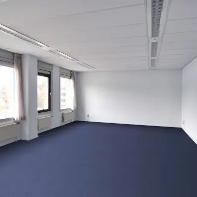 Leeg kantoor op Laan van Brabant 70-86, Roosendaal met blauwe vloerbedekking en grote ramen voor veel licht. Ideaal voor kantoorruimte huren met mogelijkheden voor eigen inrichting.