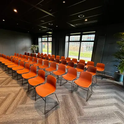 Kantoorruimte huren met moderne inrichting op George Hintzenweg 77 - 89 in Rotterdam Alexander, voorzien van oranje stoelen en grote ramen die natuurlijk licht binnenlaten.