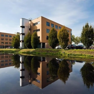 Exterieur van het kantoorpand aan de Hoofdweg 66 in Rotterdam Alexander met een weerspiegeling in het water op de voorgrond.