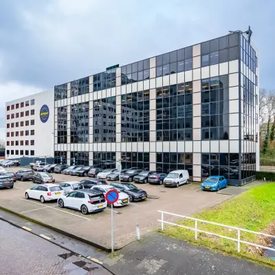 Kantoorpand aan de Marten Meesweg 8-10 in Rotterdam Alexander, met parkeergelegenheid aan de voorzijde en een moderne, glazen gevel. Ideaal voor kantoorruimte huren om te werken in een zakelijke omgeving.