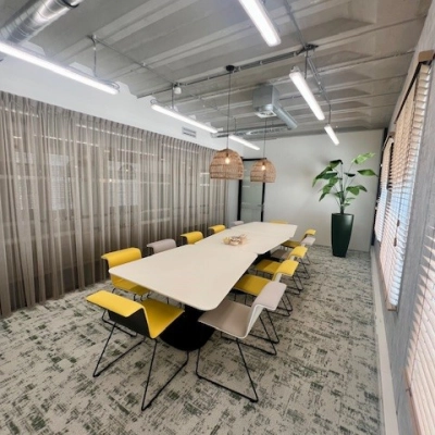 Vergaderruimte in kantoorpand op Bahialaan 100, Rotterdam Brainpark, met lange tafel en moderne verlichting. Kantoorruimte huren met comfortabele stoelen en decoratieve planten.