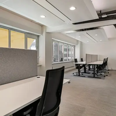 Binnenkant van een modern kantoorpand aan de Coolsingel 104 in Rotterdam Centrum met werkruimtes en bureaus.