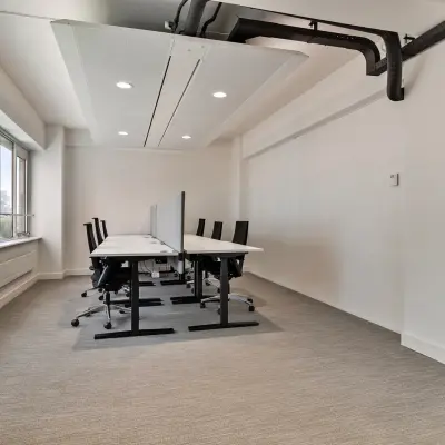 Kantoorruimte aan de Coolsingel 104 in Rotterdam Centrum, met moderne bureaus en stoelen langs een groot raam.