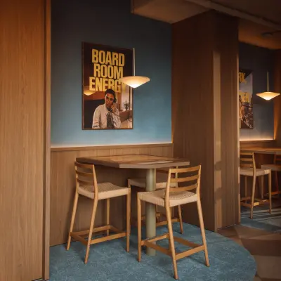 Kantoorruimte huren op Coolsingel 139, Rotterdam Centrum met houten meubels en blauwe accentmuur in een warme sfeer.
