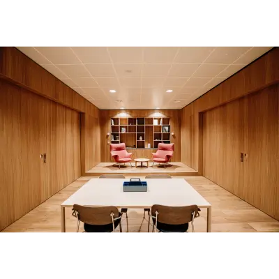 Moderne kantoorpand op Hoogstraat 185 in Rotterdam Centrum met houten wanden, een tafel met stoelen en comfortabele fauteuils. Ideale plek voor kantoorruimte huren.