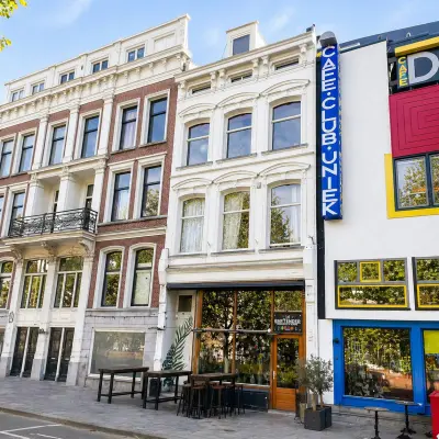 Gevels van historische panden aan de Mauritsweg in Rotterdam Centrum met daaronder een kleine buitenruimte met tafels en stoelen voor casual zakelijke bijeenkomsten.