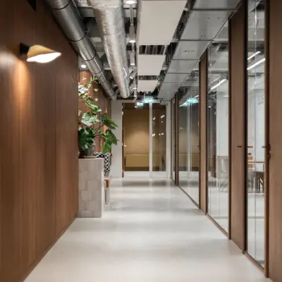 Moderne gang in een kantoorpand met houten panelen, zicht op vergaderruimtes. Ideale plek voor kantoorruimte huren in Rotterdam Centrum.