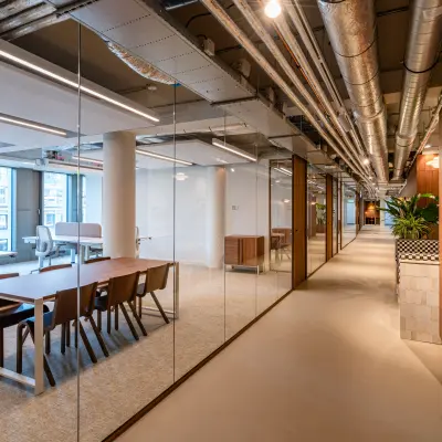 Moderne kantoorruimte te huur aan Stadhuisplein 9-23, Rotterdam Centrum, met glazen wanden en houten accenten, ideaal voor zakelijke activiteiten.