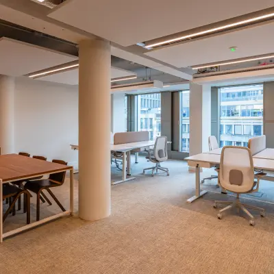 Kantoorpand aan Stadhuisplein 9-23 in Rotterdam Centrum met ruime werkplekken om te huren. Het interieur is modern en licht gemeubileerd, met grote ramen die natuurlijke lichtinval bieden voor een frisse werkomgeving.