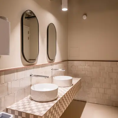 Moderne badkamer in kantoorpand Stadhuisplein 9-23, Rotterdam Centrum, met twee wastafels en spiegels. Beschikbaar voor kantoorruimte huren.